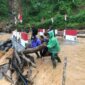Ket foto : Babinsa bersama warga memantau luapan Sungai Wih Gegaring yang menggenangi Jembatan Aramco di Desa Pantan Sinaku.(Dok/Ist)
