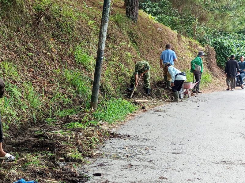 Ket Foto: Babinsa Koramil 03/Timang Gajah bersama warga Desa Mekar Ayu dan Bukit Mulie bergotong royong membersihkan bahu jalan dan parit di jalan penghubung dua desa.(Dok/Ist)