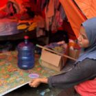 Fitriani membetulkan alas tidur yang digulung akibat hujan saat bertahan di tenda darurat di Desa Teupin Mane, Bireuen, Sabtu (2/5/2026). Foto: Dok. Istimewa 