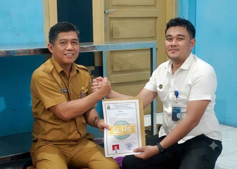 PLT Kepala Dinas Kesehatan Heri Herwanto SKM, M,Ap saat menyerahkan Sertifikat SLHS Kepada Kepala Dapur Desa Ameria Bahagia. (Foto: Dok, AgusMuliadi/Acehnow).