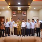 Wakil Ketua Komisi Informasi Aceh Sabri menyerahkan Anugerah Keterbukaan Informasi Publik kepada Pemerintah Kabupaten Aceh Barat saat kunjungan kerja dan evaluasi keterbukaan informasi publik di Meulaboh, Rabu (3/6/2026). Foto: Dok. Istimewa