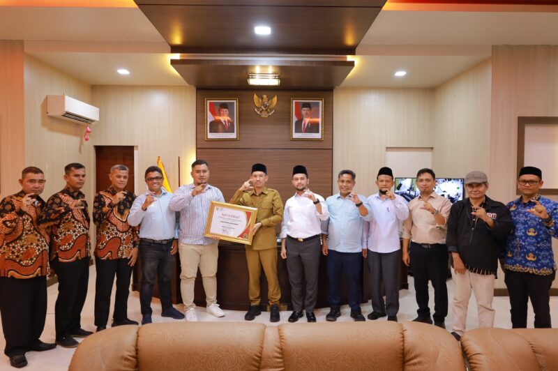 Wakil Ketua Komisi Informasi Aceh Sabri menyerahkan Anugerah Keterbukaan Informasi Publik kepada Pemerintah Kabupaten Aceh Barat saat kunjungan kerja dan evaluasi keterbukaan informasi publik di Meulaboh, Rabu (3/6/2026). Foto: Dok. Istimewa 