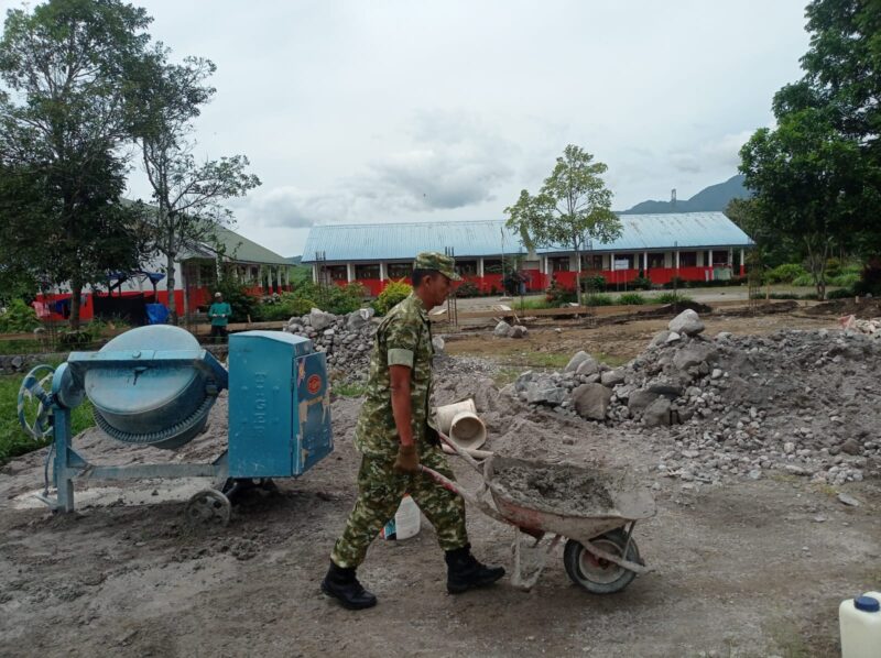 Ket foto: Babinsa Koramil 09/Ketol, Sertu Sopian turut membantu warga melakukan pengecoran tiang pembangunan gudang kopi.(Dok/Ist)