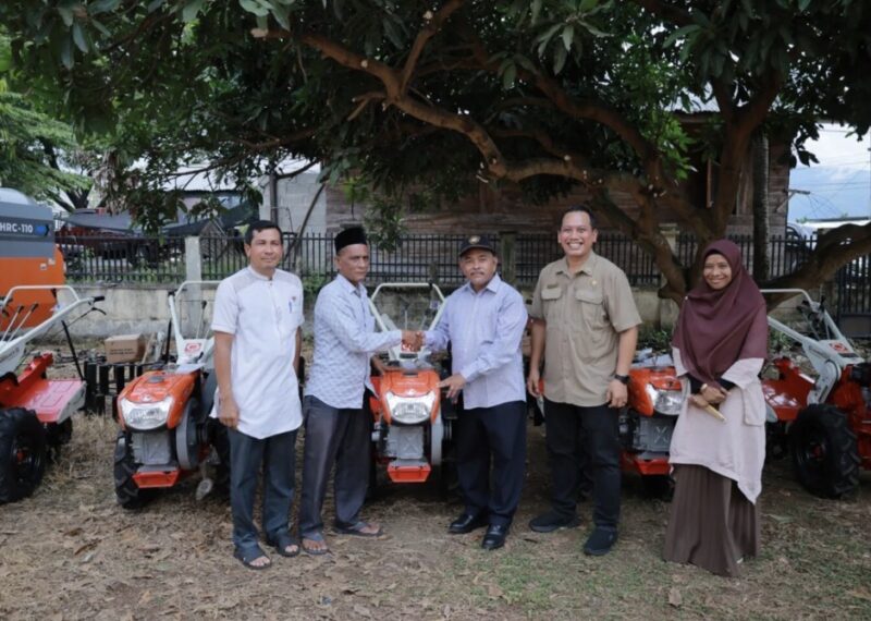 Asisten II Sekdakab Aceh Besar bersama jajaran Dinas Pertanian menyerahkan bantuan alat dan mesin pertanian (alsintan) berupa traktor dan pompa air kepada kelompok tani di Gudang Pertanian Lambaro Samahani, Kecamatan Kuta Malaka, Aceh Besar, Jumat (12/6/2026). Foto: Dok. Istimewa 