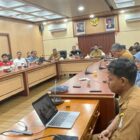 Kepala Dinas Kominsa Aceh Barat Dedi Mulianda, S.IP., M.Si. memaparkan rencana kerja sama pemanfaatan videotron sebagai media layanan informasi publik dan promosi daerah kepada perwakilan BUMN, perusahaan, serta instansi vertikal di Ruang Rapat Teuku Umar Setdakab Aceh Barat, Selasa (21/7/2026). Foto: Dok. Istimewa