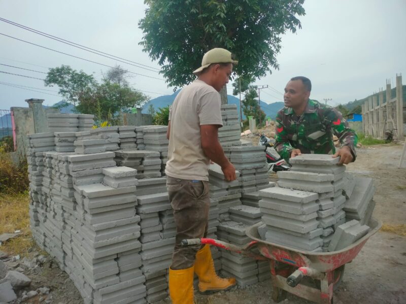 Babinsa Koramil 08/SN Koptu Zaini Saputra membantu warga mengangkat batako untuk pembangunan rumah(14/7/2026).(Dok:Ist)