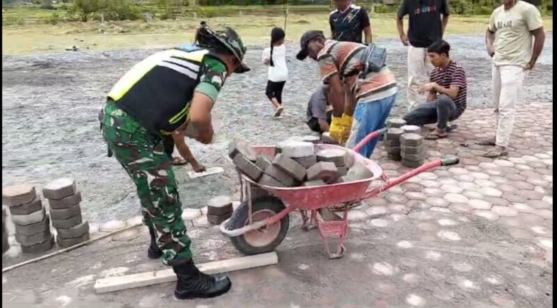 Babinsa Koramil 05/Linge Srd Irman bersama masyarakat melaksanakan gotong royong penyusunan paving block di halaman Masjid (18/7/2026).(Dok: Ist)