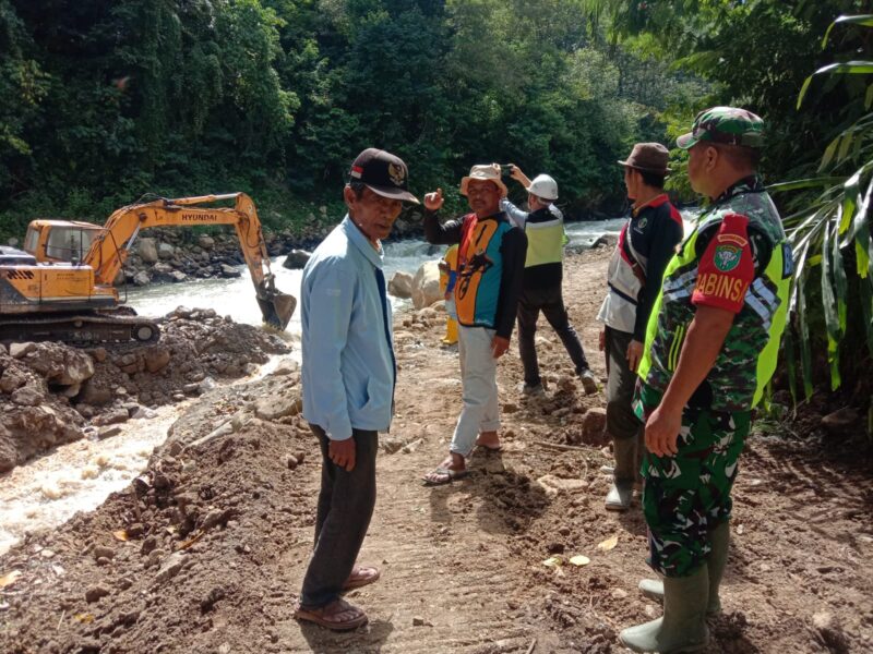 Babinsa Koramil 08/Silih Nara Serda Riswandi saat melaksanakan monitoring kegiatan normalisasi aliran sungai di Desa Burni Bius Baru, Senin (26/07/2026).(Dok:Ist)