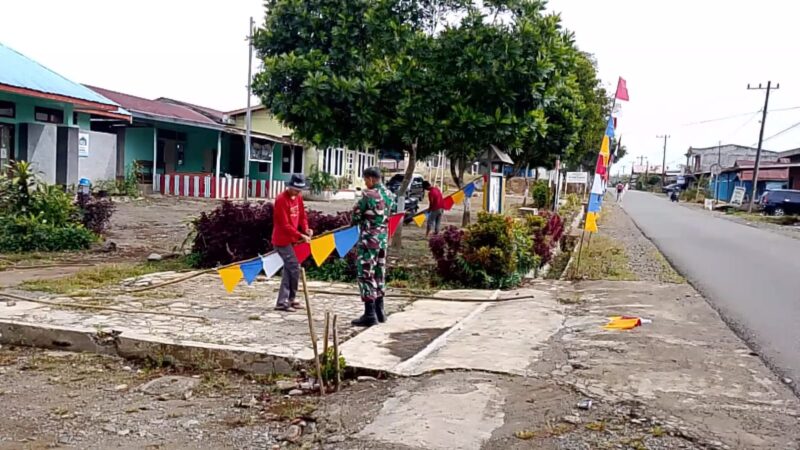 Serka Syuitno Syarifudin Lemba bersama aparatur desa dan warga melaksanakan gotong royong pemasangan umbul-umbul,Jumat (31/07/2026).Foto.Dok: Pendim 0106/Aceh Tengah.