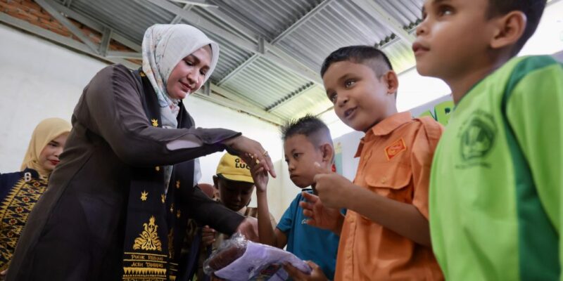 Ketua TP-PKK Aceh Ny. Marlina Muzakir, membagikan seragam sekolah kepada siswa-siswa pada peringatan Hari Anak Nasional 2026, di SLB Negeri Pembina Aceh Tamiang, Kamis (23/7/2026). Foto: Dok. Biro Adpim Setda Aceh 