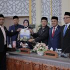 Wali Kota Banda Aceh Illiza Sa’aduddin Djamal bersama pimpinan DPRK Banda Aceh menunjukkan dokumen persetujuan bersama Rancangan Qanun tentang Pertanggungjawaban Pelaksanaan APBK Tahun Anggaran 2025 usai rapat paripurna di Gedung DPRK Banda Aceh, Jumat (24/7/2026). Foto: Dok. Prokopim Kota Banda Aceh