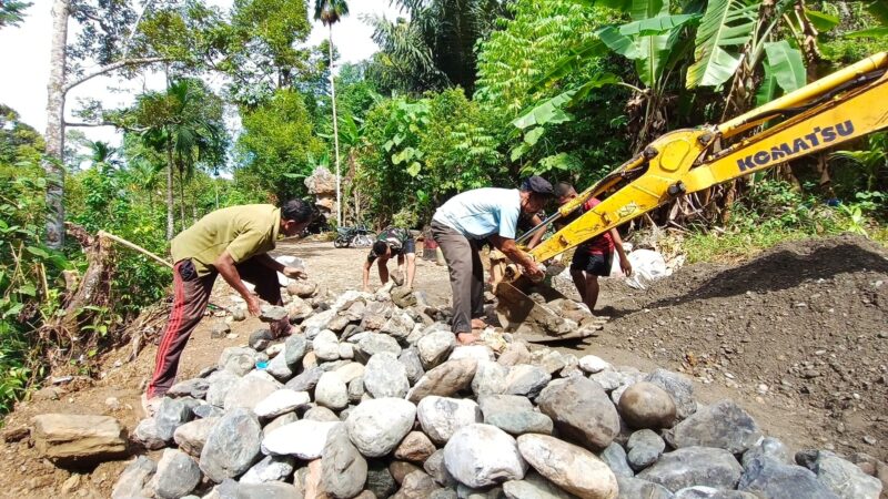 Personel Satgas TMMD Reguler ke-129 Kodim 0107/Aceh Selatan bersama masyarakat bergotong royong mengangkut batu karang sebagai material pembangunan jembatan box di Desa Kemumu Seberang, Kecamatan Labuhanhaji Timur, Jumat (7/8/2026). Foto: Dok. Istimewa 