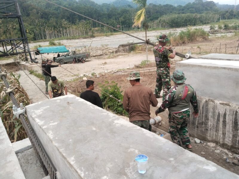 Personel bersama masyarakat mengerjakan pembangunan Jembatan Gantung Perintis Garuda Merah Putih di Desa Lawe Pinis, Kecamatan Darul Hasanah, Aceh Tenggara, Kamis (27/8/2026). Foto: Dok. Istimewa 