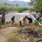 Babinsa Posramil Deleng Pokhkisen, Serda Arpit Journalis, bersama masyarakat bergotong royong menimbun bagian kiri dan kanan Jembatan Beton di Desa Bunga Melut, Kecamatan Deleng Pokhkisen, Aceh Tenggara, Sabtu (8/8/2026). Foto: Dok. Istimewa