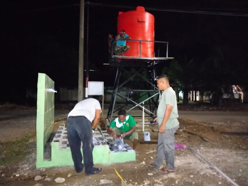 Personel Satgas TMMD ke-129 Kodim 0107/Aceh Selatan memasang jaringan pipa air dari tandon menuju titik pemanfaatan di Masjid Desa Paya Pelumat, Kecamatan Labuhanhaji Timur, Aceh Selatan, Minggu malam (9/8/2026). Foto: Dok. Istimewa 