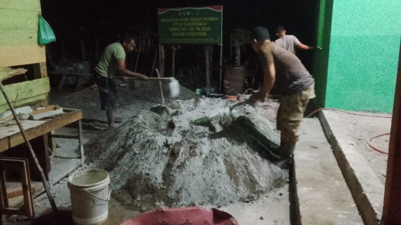 Personel Satgas TMMD Ke-129 Kodim 0102/Pidie bersama masyarakat bekerja hingga malam hari menyelesaikan pengecoran lantai Rumah Tidak Layak Huni (RTLH) di Desa Lhok Panah, Kecamatan Sakti, Rabu (5/8/2026) malam. Foto: Dok. Istimewa