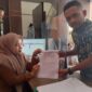 Humas Serikat Aksi Peduli Aceh (SAPA), Agusliza, menunjukkan surat permohonan keterbukaan informasi publik kepada PPID Baitul Mal Aceh terkait Program Bantuan Modal Usaha Tahun Anggaran 2026 di Banda Aceh, Rabu (5/8/2026). Foto: Dok. Istimewa 