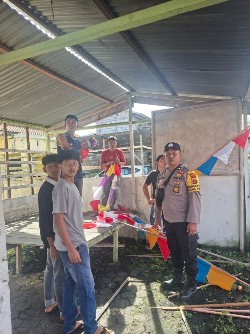 Bhabinkamtibmas Polsek Bandar Polres Bener Meriah Aipda Candra Sugara, S.H., bersama pemuda Desa Kala Nempan saat bergotong royong memasang umbul-umbul dan bendera Merah Putih dalam rangka menyambut HUT RI ke-81,3/8/2026.foto.(dok:Ist)
