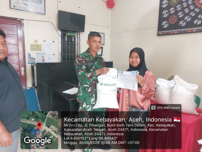Ket foto: Babinsa Koramil 01/Lut Tawar Serma Zainal Abidin mendampingi pembagian beras Bulog kepada warga, Minggu (30/8/2026).Dok: ist