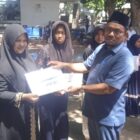 Ketua Baitul Mal Kota Banda Aceh Yusuf Al Qardhawy menyerahkan santunan kepada anak yatim pada puncak peringatan Hari Anak Nasional (HAN) 2026 di Taman Putroe Phang, Minggu (2/8/2026). Foto: Dok. Diskominfo Kota Banda Aceh