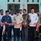 Bupati Aceh Barat Tarmizi SP, MM melakukan prosesi pemotongan pita saat meresmikan Rumah Layak Huni bantuan Forum Tokoh Peduli Aceh Barat (FTPAB) di Desa Pasi Jeut, Kecamatan Woyla Barat, Rabu (19/8/2026). Foto: Dok. Pemkab Aceh Barat