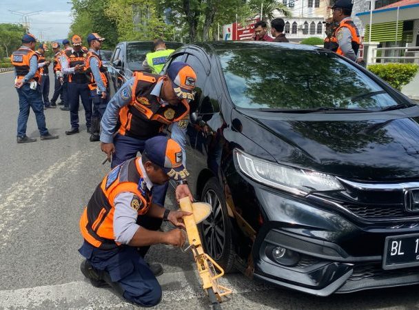 Petugas Dishub Kota Banda Aceh menggembok mobil yang kedapatan parkir di badan jalan kawasan tertib lalu lintas (KTL) Jalan T Nyak Arief, Senin (24/8/2026). Foto: Dok. Diskominfo Kota Banda Aceh