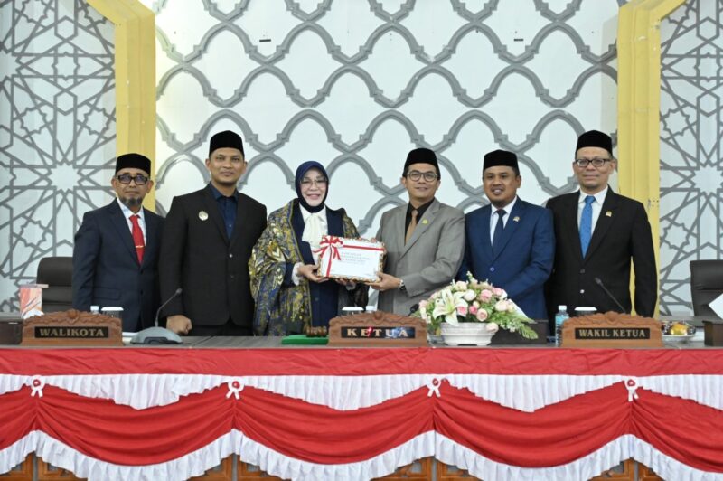 Wali Kota Banda Aceh Illiza Sa’aduddin Djamal menyerahkan dokumen RKUA-PPAS Perubahan APBK Tahun Anggaran 2026 kepada Ketua DPRK Banda Aceh Irwansyah ST didampingi Wakil Ketua Daniel Abdul Wahab dan Musriadi Aswad dalam sidang paripurna di Gedung DPRK Banda Aceh, Senin (24/8/2026). Foto: Dok. DPRK Banda Aceh