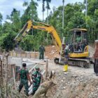 Personel Satgas TMMD Reguler ke-129 Kodim 0102/Pidie memasang cerucuk kayu menggunakan mini excavator sebagai penahan bantaran jalan pada pembangunan Jembatan Box Culvert di Desa Lhok Panah, Kecamatan Sakti, Jumat (7/8/2026). Foto: Dok. Istimewa