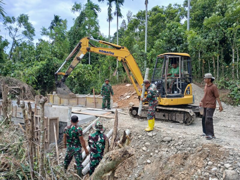Personel Satgas TMMD Reguler ke-129 Kodim 0102/Pidie memasang cerucuk kayu menggunakan mini excavator sebagai penahan bantaran jalan pada pembangunan Jembatan Box Culvert di Desa Lhok Panah, Kecamatan Sakti, Jumat (7/8/2026). Foto: Dok. Istimewa 
