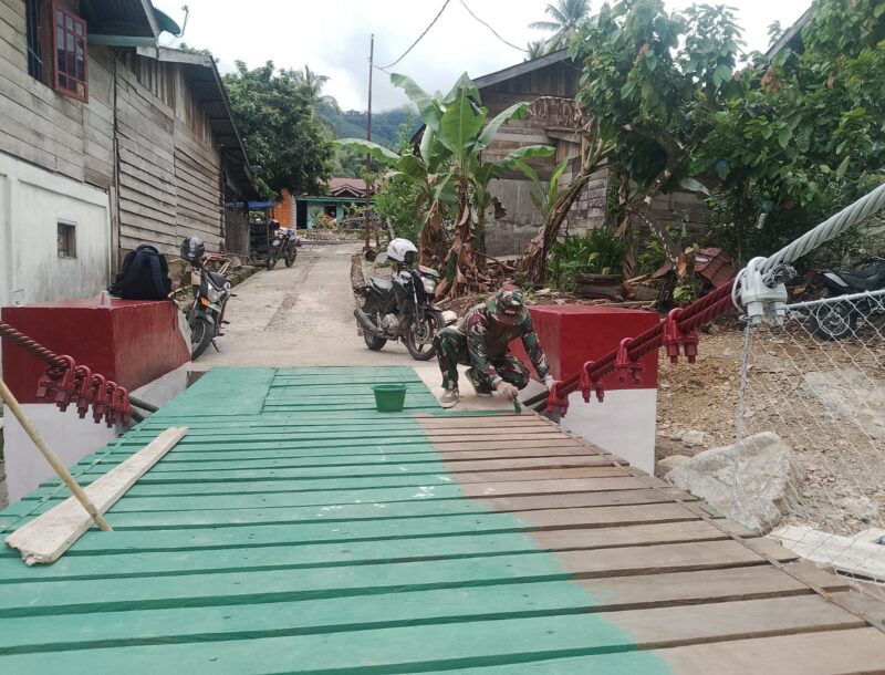 Personel Babinsa Kodim 0108/Aceh Tenggara bersama warga bergotong royong menyelesaikan pengecatan Jembatan Gantung Perintis di Desa Kuning Abadi, Kecamatan Ketambe, yang kini telah mencapai progres pembangunan 95,5 persen, Selasa (4/8/2026). Foto: Dok. Istimewa 