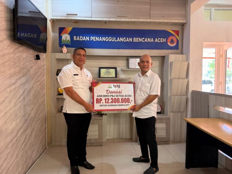 Plt. Kepala Biro PBJ Setda Aceh Ir. Afria menyerahkan donasi sebesar Rp12,3 juta kepada Plt. Sekretaris BPBA Abd. Aziz untuk membantu korban gempa bumi di Nusa Tenggara Timur (NTT), di Kantor BPBA, Banda Aceh, Rabu (26/8/2026). Foto: Dok. Istimewa 
