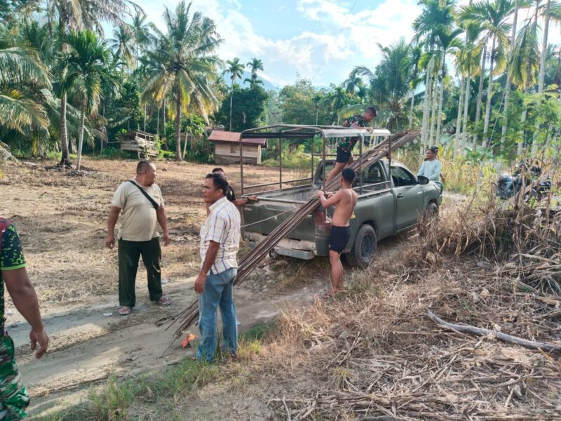 Personel Satgas Jembatan Gantung Kodim 0108/Agara bersama masyarakat bergotong royong menurunkan dan memindahkan material besi pondasi pembangunan Jembatan Gantung Perintis Garuda di Desa Lawe Pinis, Kecamatan Darul Hasanah, Aceh Tenggara, Sabtu (29/8/2026). Foto: Dok. Istimewa 