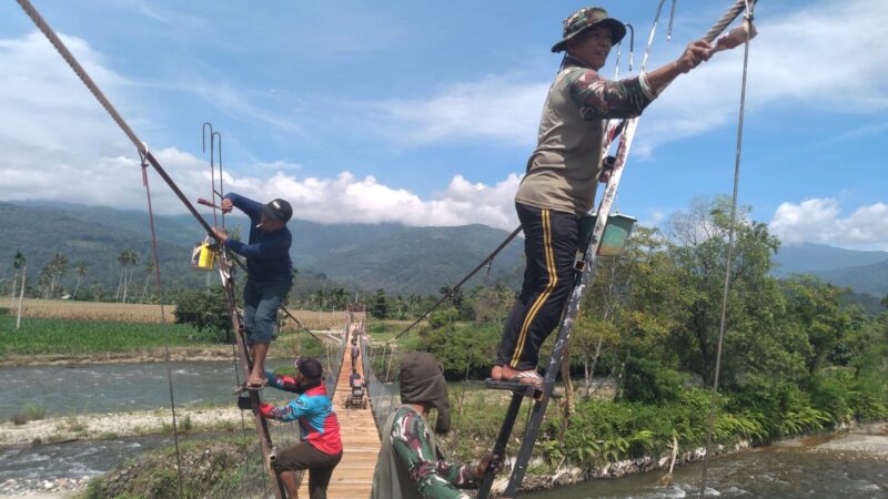 Babinsa Posramil Deleng Pokhkisen bersama masyarakat memasang besi pagar pengaman pada Jembatan Beton di Desa Bunga Melur, Kecamatan Deleng Pokhkisen, Aceh Tenggara, Minggu (9/8/2026). Foto: Dok. Istimewa 