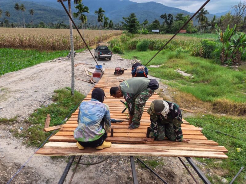 Personel Satgas Jembatan Gantung Perintis Kodim 0108/Aceh Tenggara bersama teknisi memasang papan lantai jembatan di Desa Kuta Ujung, Kecamatan Darul Hasanah, Aceh Tenggara, Jumat (7/8/2026). Foto: Dok. Istimewa 