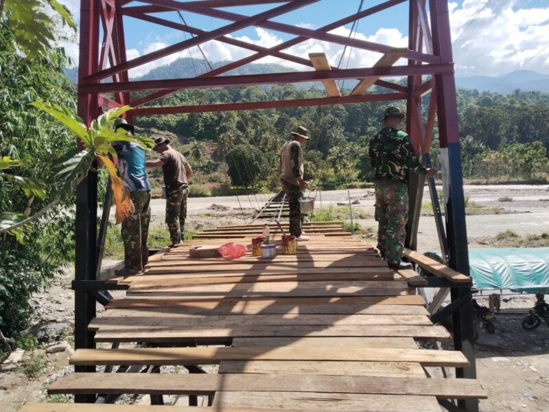 Babinsa bersama masyarakat melakukan pengecatan tiang pylon Jembatan Gantung Perintis yang menghubungkan wilayah Kecamatan Darul Hasanah dengan Desa Kumbang Jaya, Kecamatan Badar, Aceh Tenggara, Selasa (22/9/2026). Foto: Dok. Istimewa 