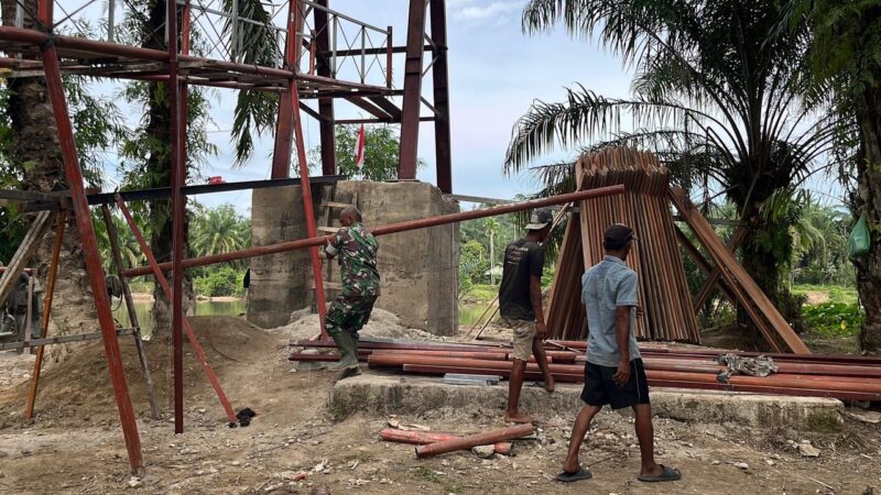 Personel TNI bersama pekerja sipil dan masyarakat bergotong royong mengerjakan pembangunan Jembatan Gantung Desa Serasah, Kecamatan Simpang Kanan, Aceh Singkil, Senin (31/8/2026). Foto: Dok. Istimewa 