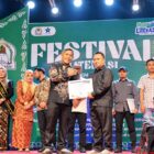 Sekda Aceh Barat, Dr. Ir. Kurdi, ST, MT, MH, IPM, ASEAN-Eng, menyerahkan penghargaan kepada Sekjen SMSI Aceh Barat, Riosa, sebagai Organisasi Media Pegiat Literasi Kabupaten Aceh Barat Tahun 2026, pada malam penutupan Festival Literasi Aceh Barat 2026, Sabtu (26/9/2026). Foto: Dok. SMSI Aceh Barat