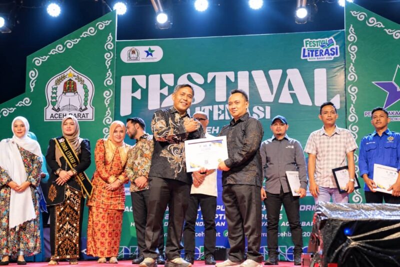 Sekda Aceh Barat, Dr. Ir. Kurdi, ST, MT, MH, IPM, ASEAN-Eng, menyerahkan penghargaan kepada Sekjen SMSI Aceh Barat, Riosa, sebagai Organisasi Media Pegiat Literasi Kabupaten Aceh Barat Tahun 2026, pada malam penutupan Festival Literasi Aceh Barat 2026, Sabtu (26/9/2026). Foto: Dok. SMSI Aceh Barat