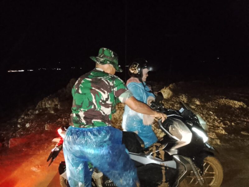 Ket Foto: Babinsa Koramil 01/Lut Tawar Kopka Ansaraya Ginting membantu pengguna jalan saat melintas di lokasi longsor, (13/9/2026) malam.dok: Ist
