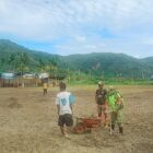 Ket Foto: Babinsa Koramil 10/Celala Serda Baihaki bersama warga dan pemuda bergotong royong merapikan lapangan sepak bola .(Dok:Ist