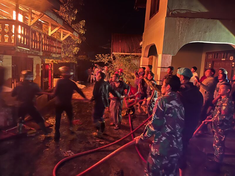 Ket Foto: Personel Koramil 01/Lut Tawar bersama petugas Damkar, personel Polri dan masyarakat membantu memadamkan kebakaran dua rumah warga, Jumat (18/9/2026) malam.(Dok:Ist)