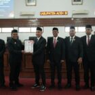Bupati Aceh Besar H Muharram Idris (Syech Muharram), menyerahkan Pengantar Nota Keuangan dan Rancangan Qanun tentang P-APBK Aceh Besar Tahun Anggaran 2026 kepada Ketua DPRK Aceh Besar Abdul Muchti SIKom, dalam rapat paripurna di Aula Rapat Gedung DPRK Aceh Besar, Kota Jantho, Kamis (24/9/2026). Foto: Dok. MC Aceh Besar