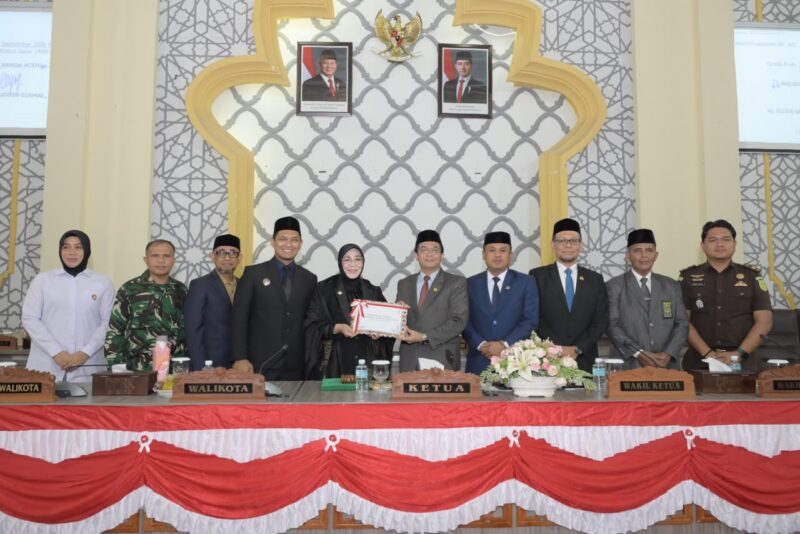 Wali Kota Banda Aceh Illiza Sa’aduddin Djamal menyerahkan dokumen Rancangan Qanun Perubahan APBK Tahun Anggaran 2026 kepada Ketua DPRK Banda Aceh Irwansyah dalam rapat paripurna, Senin (14/9/2026). Foto: Dok. DPRK Banda Aceh