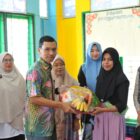 Ketua Komisi IV DPRK Banda Aceh Farid Nyak Umar saat menyerahkan asupan nutrisi kepada anak-anak dalam kegiatan sosialisasi gizi di salah satu gampong di Kota Banda Aceh, Rabu (16/9/2026). Foto: Dok. DPRK Banda Aceh