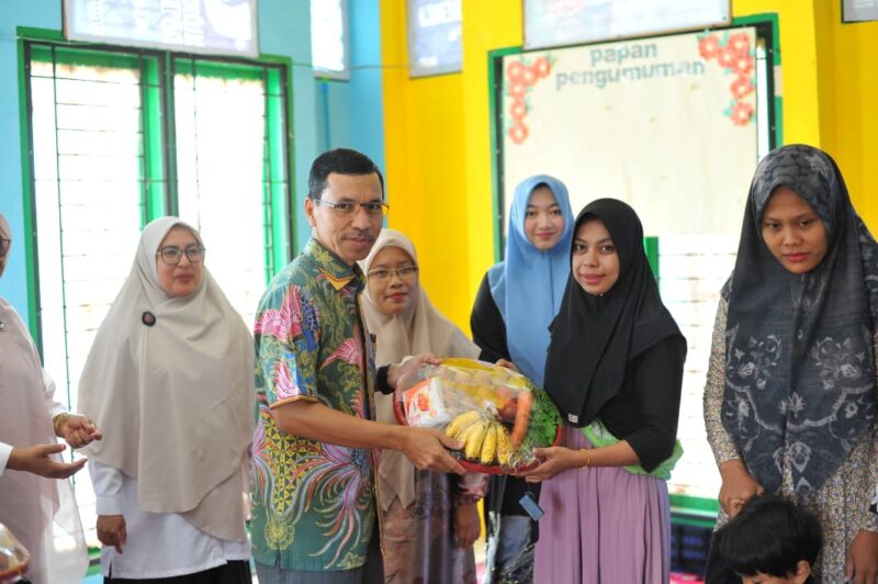 Ketua Komisi IV DPRK Banda Aceh Farid Nyak Umar saat menyerahkan asupan nutrisi kepada anak-anak dalam kegiatan sosialisasi gizi di salah satu gampong di Kota Banda Aceh, Rabu (16/9/2026). Foto: Dok. DPRK Banda Aceh