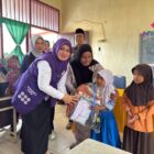 Ketua Posyandu Kabupaten Aceh Barat, Afrinda Novalia, menyerahkan bantuan perlengkapan sekolah kepada siswa terdampak bencana hidrometeorologi di SDN Alue Lhok, Kecamatan Pante Ceureumen, Kamis (29/10/2026). Foto: Dok. Istimewa