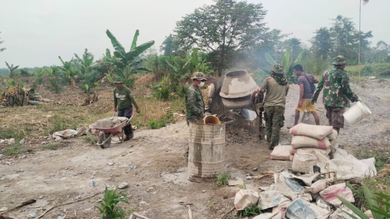 Babinsa dan warga bekerja sama menyiapkan konstruksi kaki tiang pylon sebagai bagian dari pembangunan Jembatan Gantung Perintis di Desa Buah Pala, Kecamatan Lawe Sumur, Jumat (16/10/2026). Foto: Dok. Istimewa 