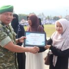 Pasi Pers Kodim 0106/Aceh Tengah Kapten Inf Ridwan menyerahkan piagam penghargaan kepada santriwati berprestasi pada upacara peringatan Hari Santri Nasional, Kamis (22/10/2026).dok:Ist